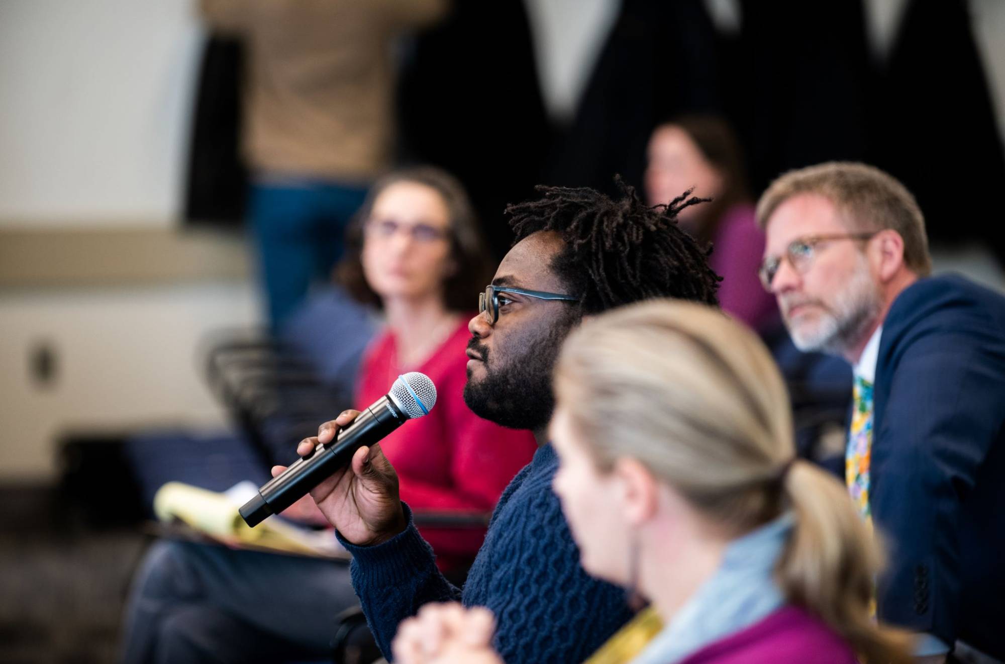 A student asks a question to a faculty member following a presentation
